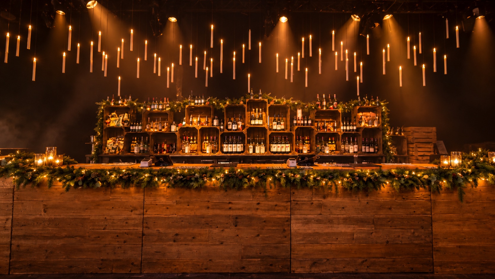 Christmas bar concept with a timber counter, festive greenery and hanging candle lights